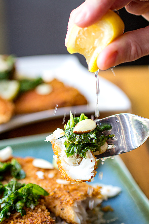 Piece of Pan Fried Fish on a fork with a lemon squeezed over top | thecozyapron.com