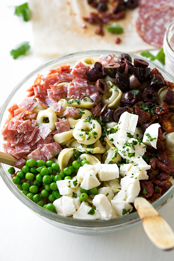 A mixing bowl full of Tortellini Pasta Salad ingredients | thecozyapron.com