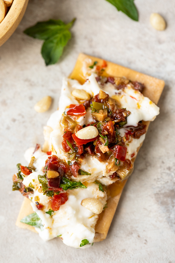 Burrata Recipe with Olive and Pepper Vinaigrette on a Cracker | thecozyapron.com