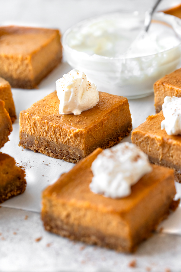 Closeup of Pumpkin Pie Bars with a dollop of whipped cream | thecozyapron.com