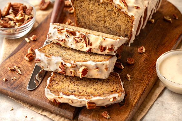 A freshly baked loaf of Buttered Pecan Banana Bread sliced and ready to enjoy | thecozyapron.com