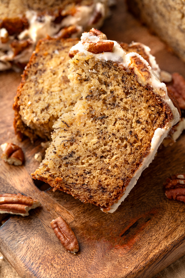 Slice of Buttered Pecan Banana Bread Showing the moist crumb texture and pecan topping