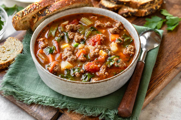 A big bowl of Easy Vegetable Beef Soup with a few slices of bread | thecozyapron.com