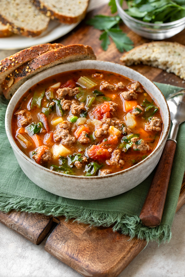 A big bowl of Easy Vegetable Beef Soup with a few slices of bread | thecozyapron.com