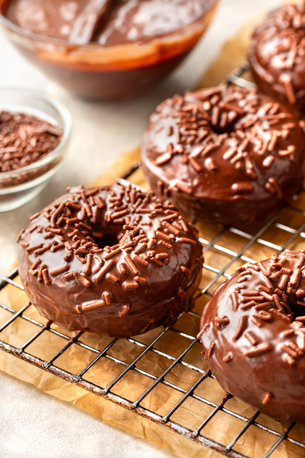 Freshly baked Chocolate Glazed Donuts on a wire rack | thecozyapron.com