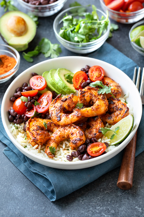 Blackened Shrimp Bowl topped with fresh cilantro, and with the ingredients in the background | thecozyapron.com