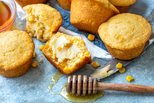 A fresh Cornbread Muffin with a honey dipper full of honey | thecozyapron.com