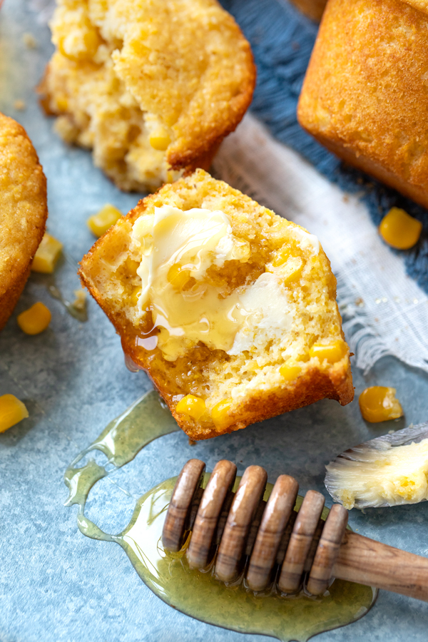 Closeup on the inside of a fresh Cornbread Muffin with a honey dipper full of honey | thecozyapron.com