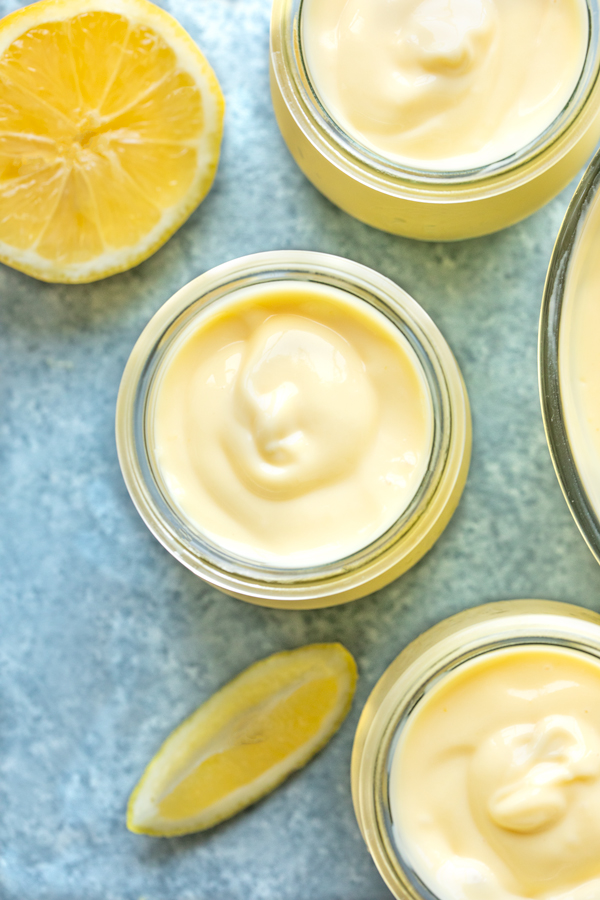 Overhead shot of 3 jars of freshly made Lemon Pudding, with a couple lemon cookie straws | thecozyapron.com