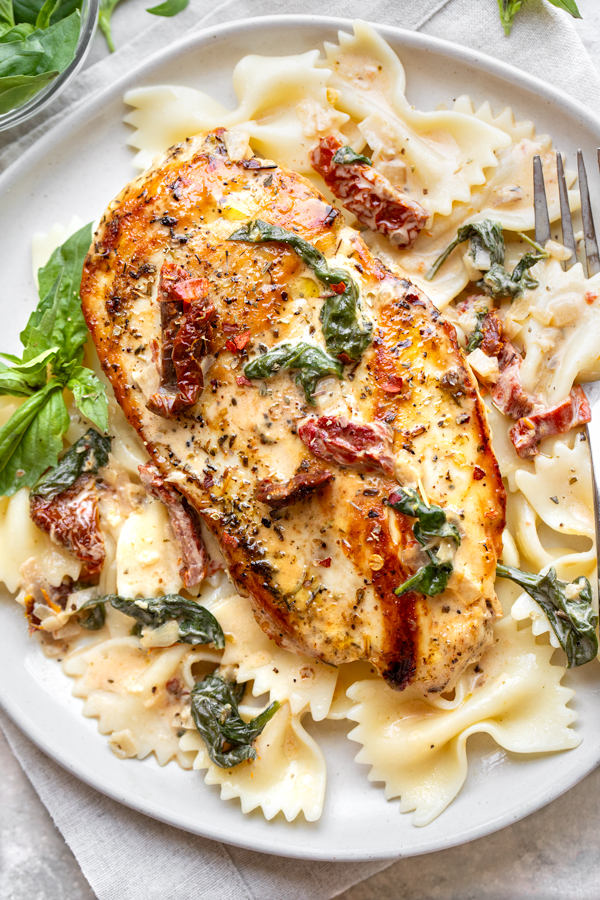 Tuscan Chicken Served over Bow Tie Pasta | thecozyapron.com