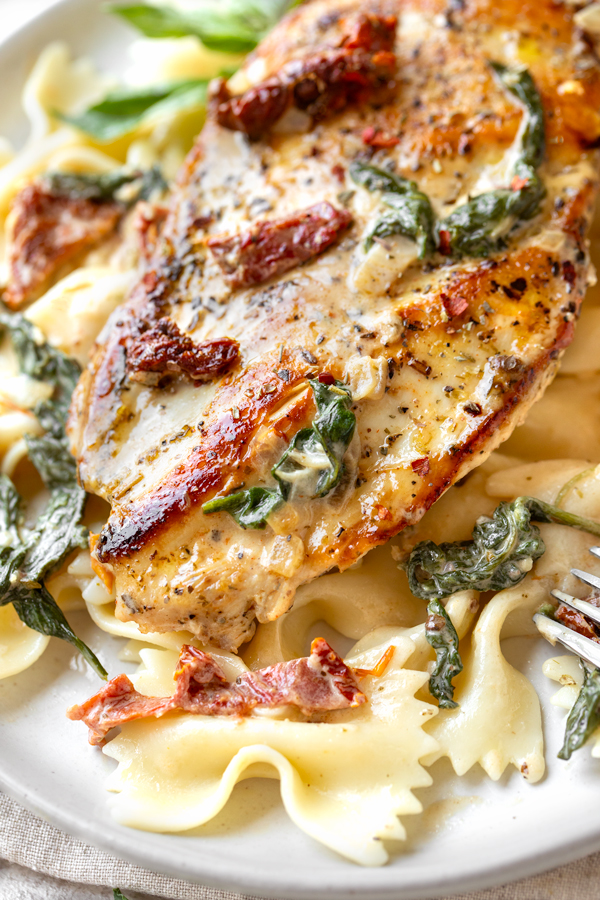Closeup on Tuscan Chicken Served over Bow Tie Pasta | thecozyapron.com