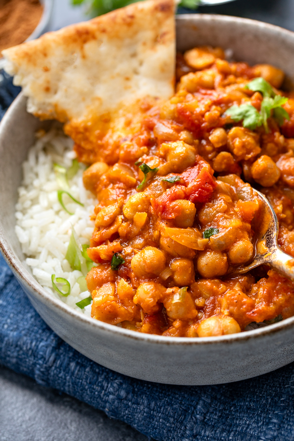 Closeup on a bowl of Chana Masala with rice and naan | thecozyapron.com