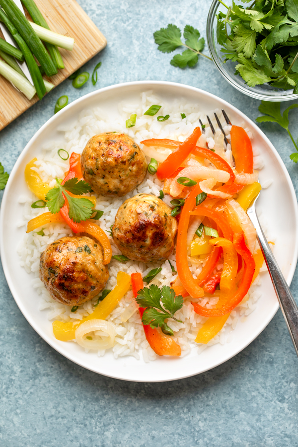 A plate of Chicken Meatballs with Peppers and Onions over Rice | thecozyapron.com
