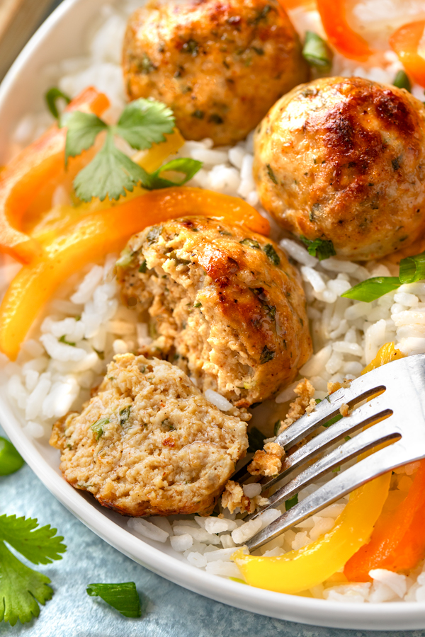 Closeup on the inside of a Chicken Meatball on a bed of rice, with Peppers and Onions | thecozyapron.com