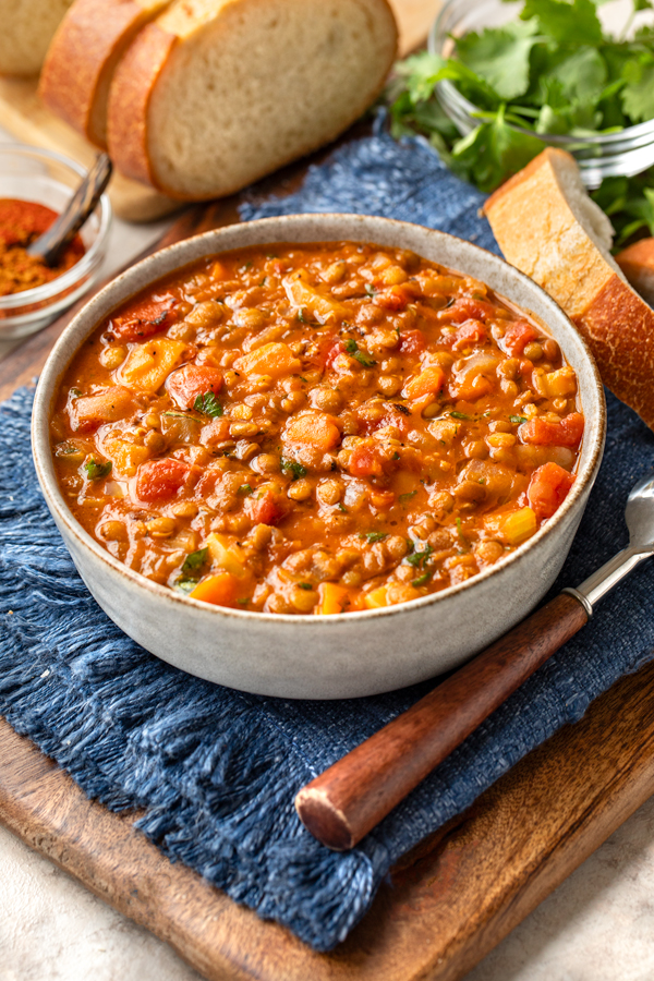 A hot bowl of Lentil Vegetable Soup sliced bread | thecozyapron.com