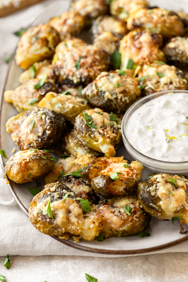 Smashed Brussels Sprouts served on a platter, with Lemon Garlic Dipping Sauce | thecozyapron.com