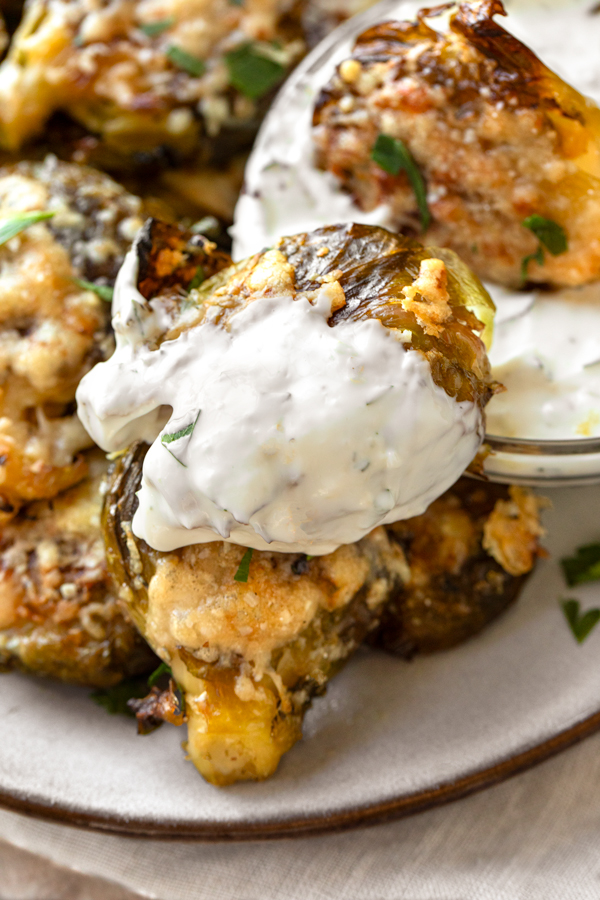 Closeup on a Smashed Brussels Sprout, drenched with Lemon Garlic Dipping Sauce | thecozyapron.com