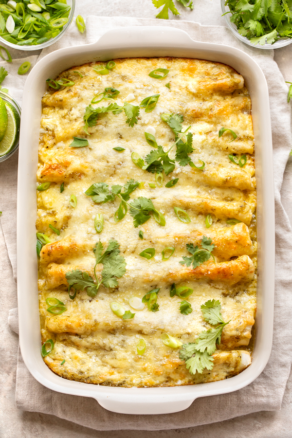 Overhead shot on a baking dish of Salsa Verde Chicken Enchiladas fresh out of the oven | thecozyapron.com