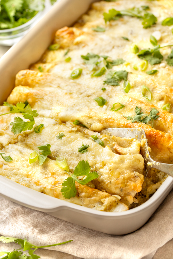A baking dish of Salsa Verde Chicken Enchiladas fresh out of the oven | thecozyapron.com