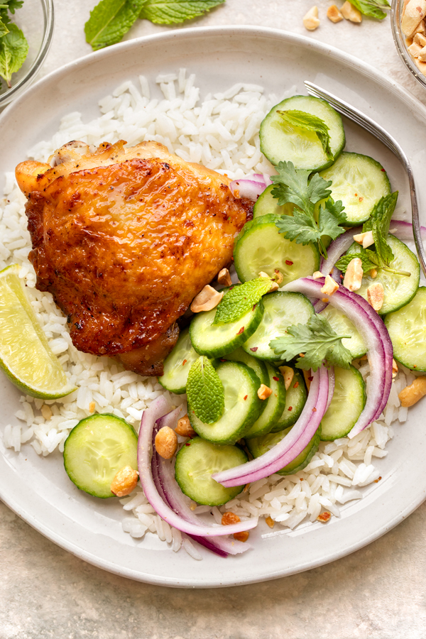 A scrumptious plate of fresh Thai Cucumber Salad with a savory roasted Chicken Thigh and fluffy Rice | thecozyapron.com