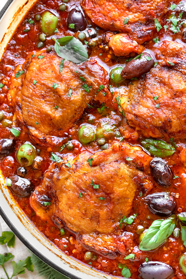 Closeup, overhead shot of homemade Chicken Puttanesca served in a cast iron braiser | thecozyapron.com