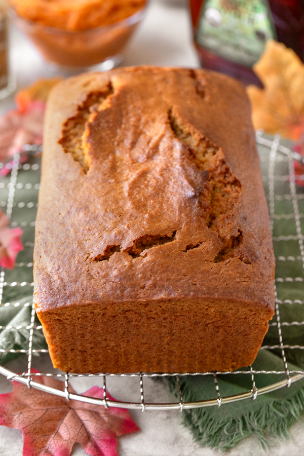 A freshly baked Maple Sweet Potato Bread loaf cooling on a wire Rack | thecozyapron.com