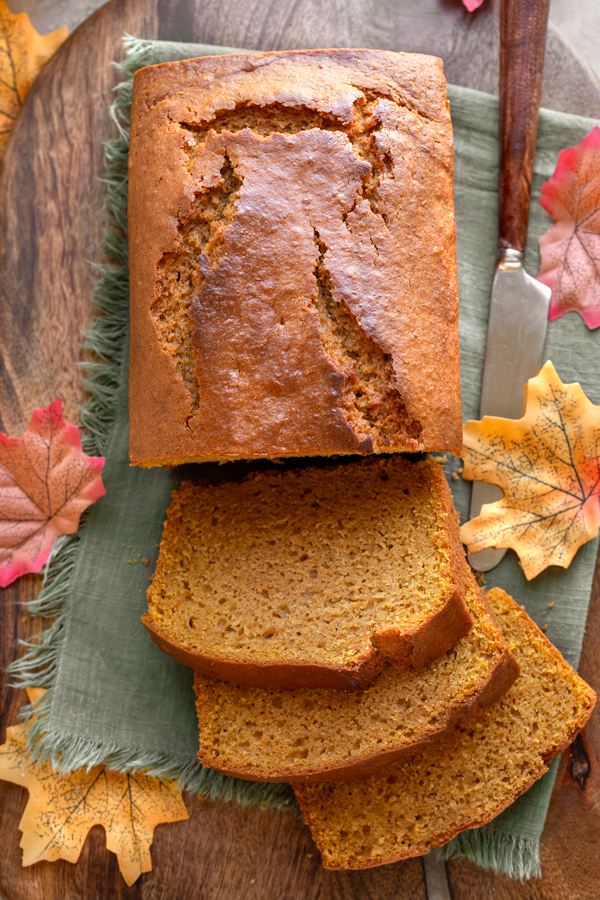 Overhead shot on a freshly baked loaf of Maple Sweet Potato Bread with a few slices on a cutting board | thecozyapron.com