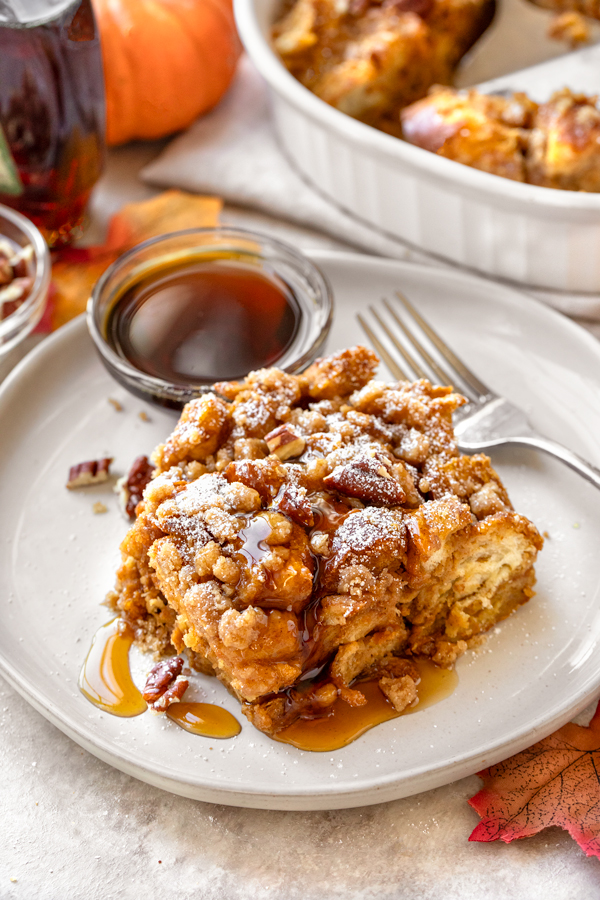 A generous serving of warm Pumpkin French Toast Casserole with maple syrup on the side | thecozyapron.com