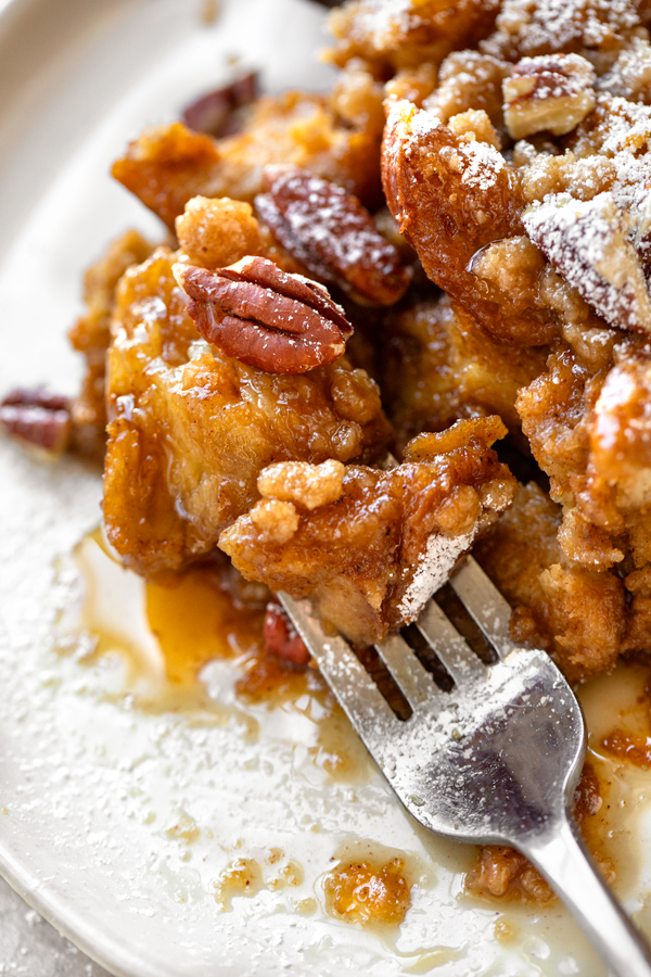 Closeup on a forkful of Pumpkin French Toast Casserole drenched in maple syrup | thecozyapron.com