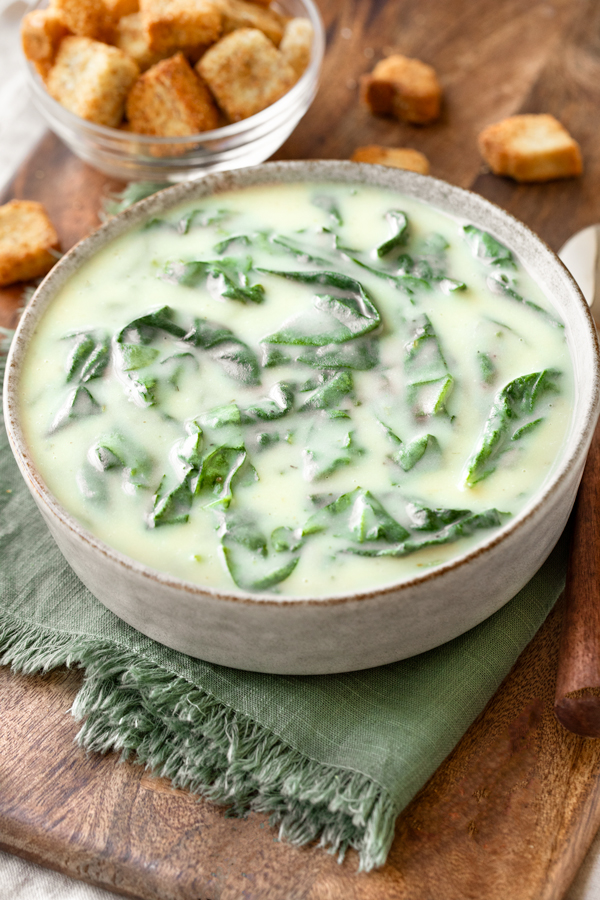 A bowl of homemade Spinach Soup with crispy croutons on the side | thecozyapron.com
